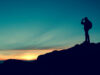 Eine Silhouette eines Wanderers auf einem Berg bei Sonnenuntergang