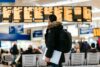 Passagier mit Laptop in der Hand am Flughafen