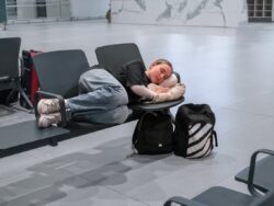 Schlafende Frau auf den Sitzen am Flughafen