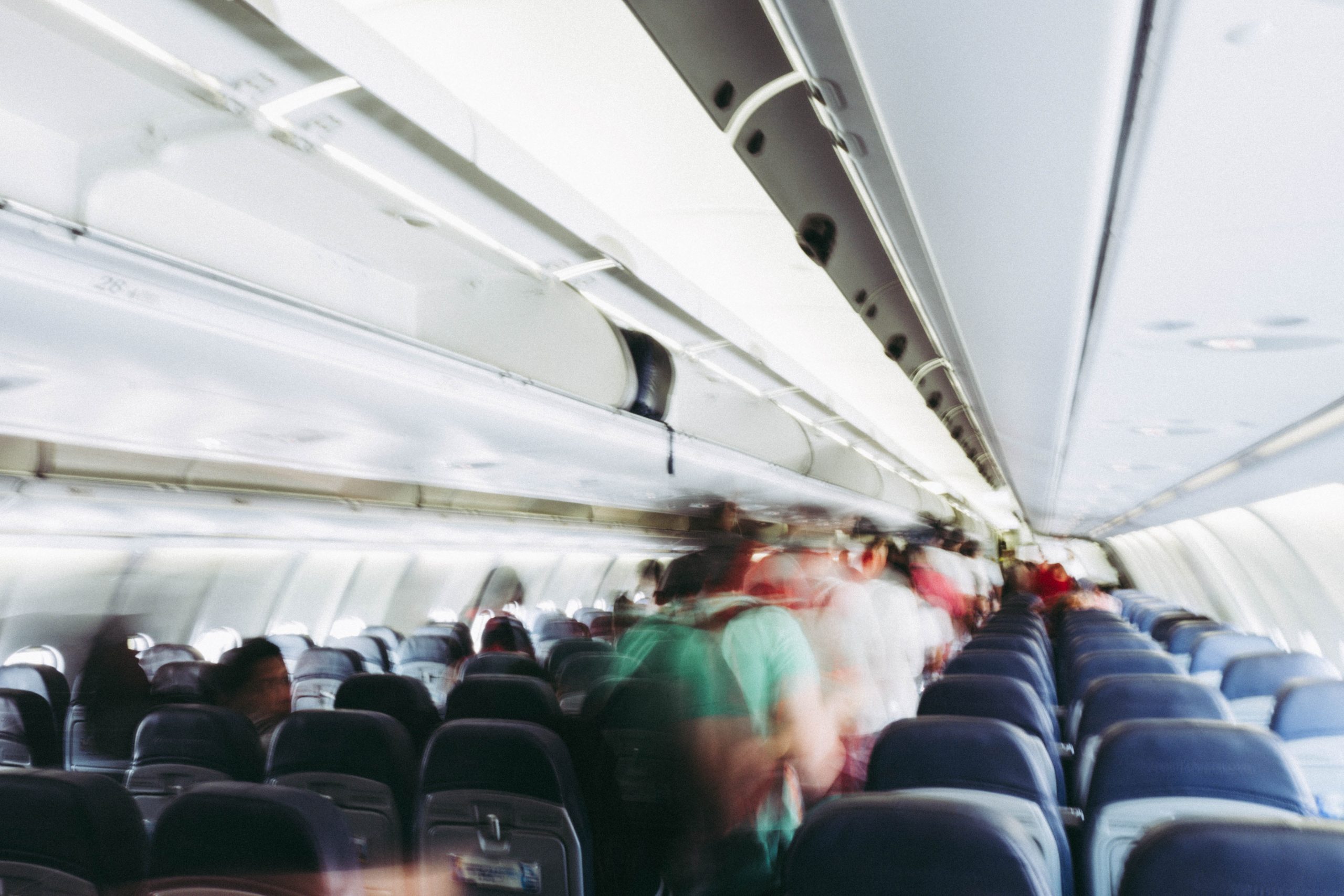 Passagiere steigen mit ihrem Handgepäck ins Flugzeug