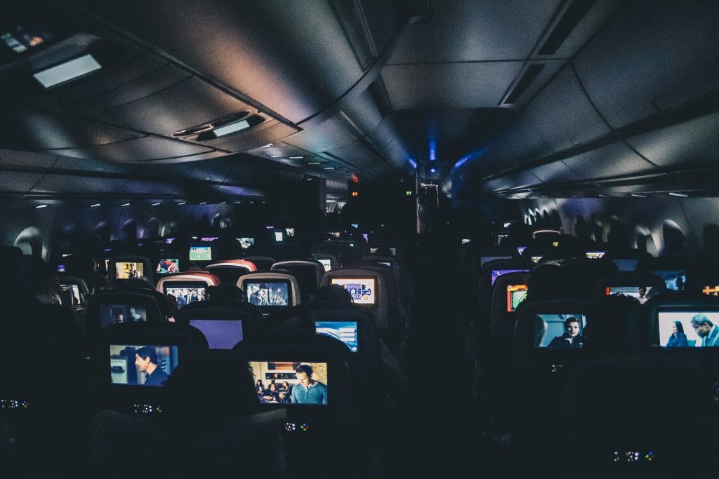 Auf einem Langstreckenflug schauen die Passagiere Filme