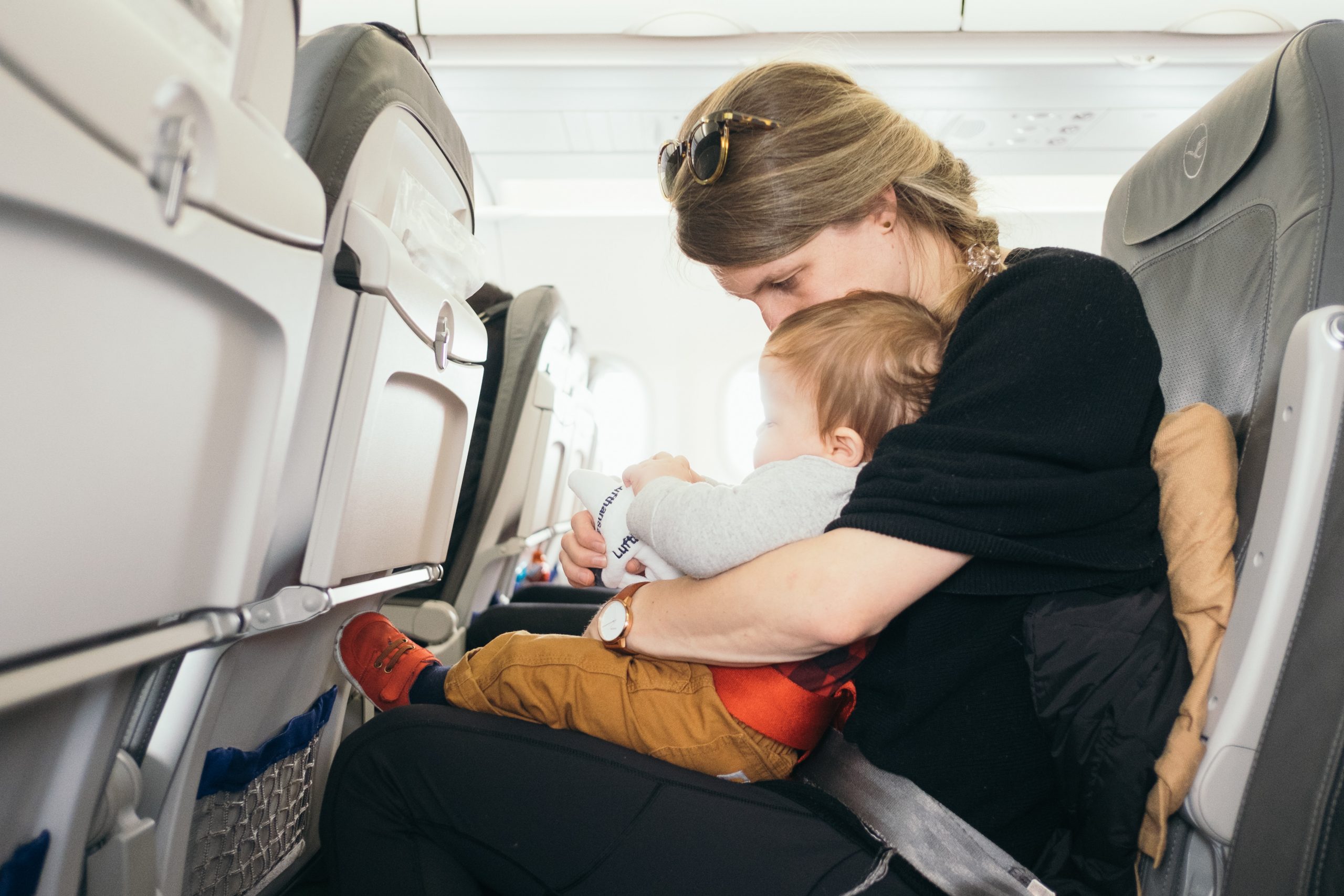 Eine Mutter mit ihrem Baby im Flugzeug auf dem Weg in den Urlaub